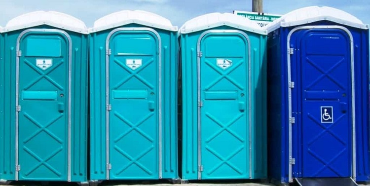 Quatro banheiros químicos em tons de azul dispostos em fileira