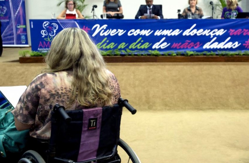 Em audiência da Câmara sobre mudanças na lei de cotas, uma mulher está de costas para a câmera, em sua cadeira de rodas. À sua frente, está a bancada de deputados.