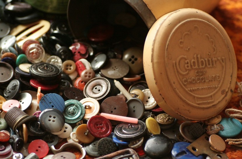 Diversos botões de lata e vintage espalhados em uma mesa
