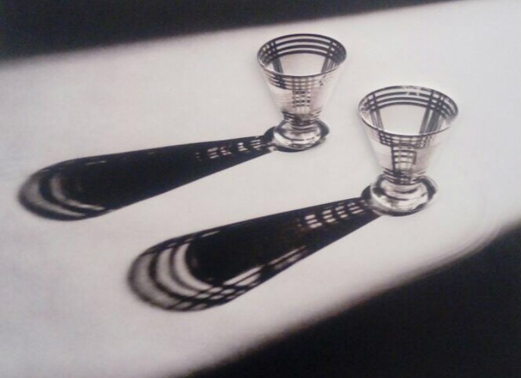 Foto de obra tátil que representa uma fotografia com dois copos em cima de uma mesa e suas sombras