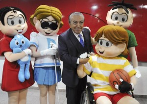 Foto do cartunista Maurício de Sousa posando ao lado de seus personagens. Da esquerda para a direita: Mônica, Dorinha, que tem deficiência visual, Maurício, Luca, que é cadeirante, e Cebolinha