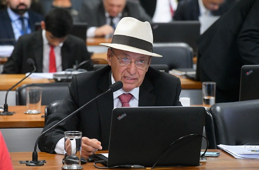 Foto do senador Antonio Carlos Valadares, um homem de 75 anos, branco e calvo, com óculos e um chapéu panamá durante sessão no Senado Nacional