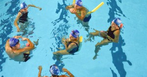 Foto em plano plongée dos alunos na piscina durante a aula