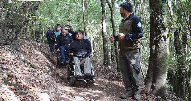 Foto de um grupo de pessoas cadeirantes fazendo uma trilha