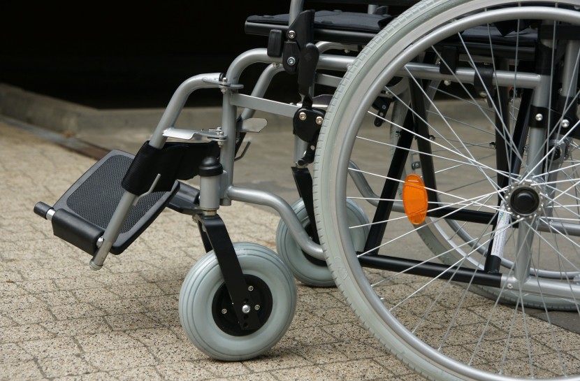 Foto de uma cadeira de rodas parada em cima de uma calçada.