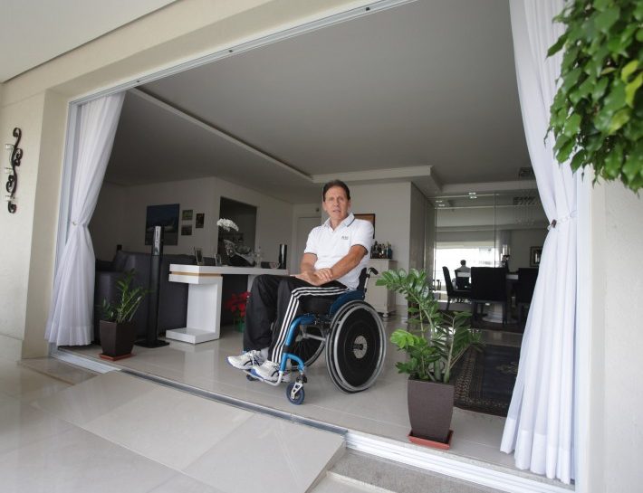 Foto de um homem cadeirante em uma sala